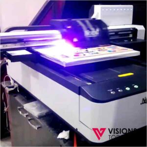 Laser engraver in operation, bright blue/purple laser profiling a colorful panel on a white/gray machine.
